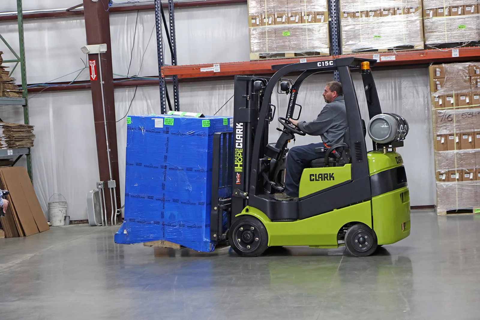Clark C15C forklift carrying a wrapped pallet past pallet racking in a Central PA warehouse