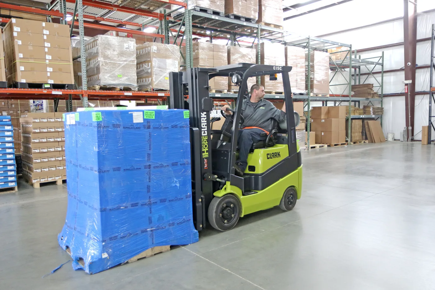 Clark C15C forklift moving a wrapped pallet past pallet racking in a Central PA warehouse